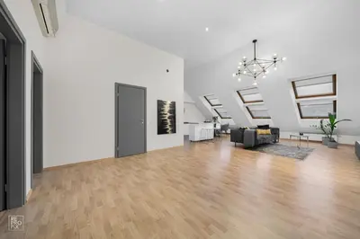 an empty living room with white walls and wood floors at Kaunas Old Town apartment with underground parking in Kaunas