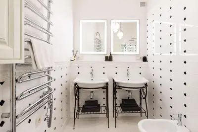 a white bathroom with two sinks and two mirrors at Luxury 2BDR Heart Of Old Town in Vilnius