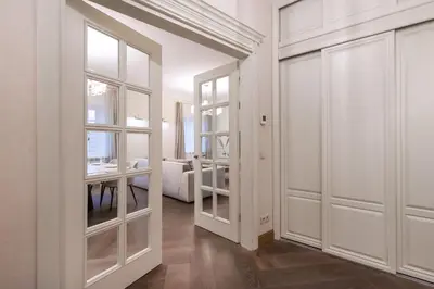 a room with white doors and a room with a bedroom at Luxury 2BDR Heart Of Old Town in Vilnius
