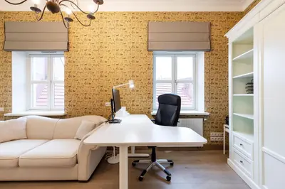 an office with a white desk and a couch at Luxury 2BDR Heart Of Old Town in Vilnius