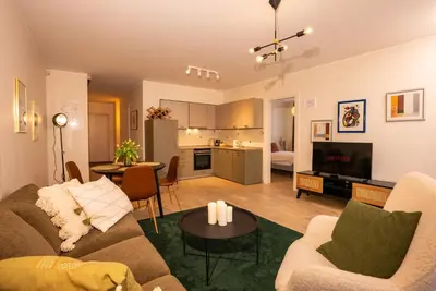 a living room with a couch and a table at Cozy Center Druskininkai in Druskininkai