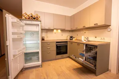 a kitchen with an empty refrigerator and an open door at Cozy Center Druskininkai in Druskininkai