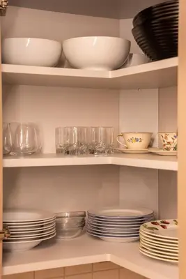 a pantry with plates and bowls on shelves at Cozy Center Druskininkai in Druskininkai