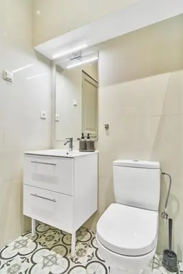 a white bathroom with a toilet and a mirror at New and Lovely Apartament in Vilnius City Centre in Vilnius