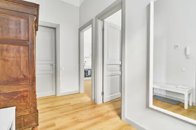 a hallway with two mirrors and a wooden door at New and Lovely Apartament in Vilnius City Centre in Vilnius