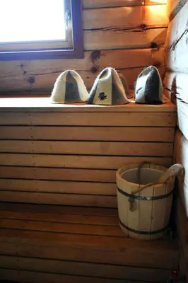 a wooden room with a window with a bucket at Kaimukas - namelis prie ežero keturiems in Dvarčėnai