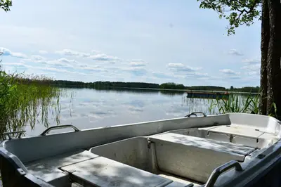 a boat sitting in the water on a lake at Kaimukas - namelis prie ežero keturiems in Dvarčėnai