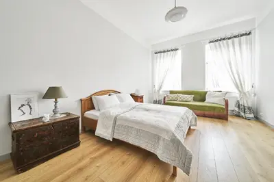 a white bedroom with a bed and a couch at Bright and Warm Apartment, Vilnius City Centre in Vilnius