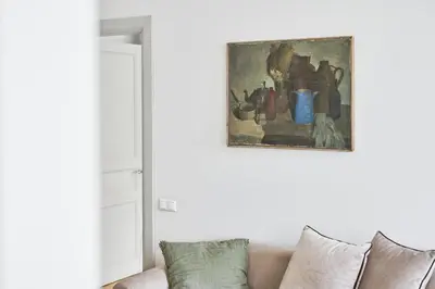 a living room with a couch and a painting on the wall at Bright and Warm Apartment, Vilnius City Centre in Vilnius