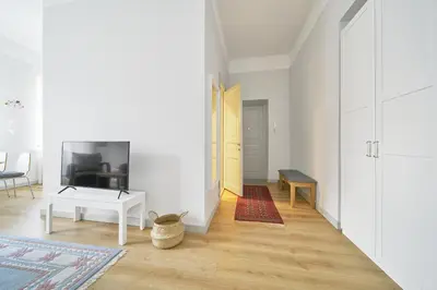a living room with a white door and a table at Bright and Warm Apartment, Vilnius City Centre in Vilnius