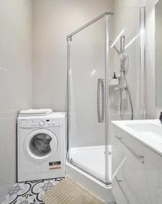 a bathroom with a washing machine and a sink at Bright and Warm Apartment, Vilnius City Centre in Vilnius