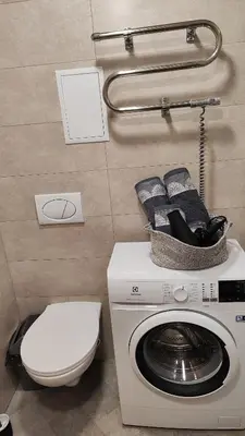 a bathroom with a washing machine and a toilet at Adelės apartamentai in Druskininkai
