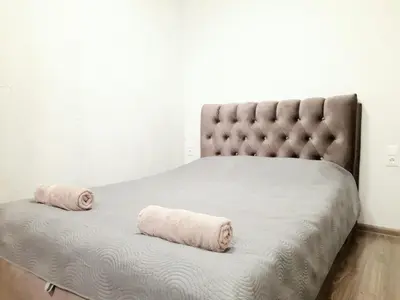 a bed with two rolled up towels on it at M&M Apartment II SELF CHECK-IN in Panevėžys