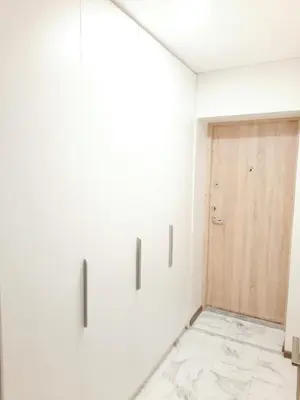 a hallway with white walls and a wooden door at M&M Apartment II SELF CHECK-IN in Panevėžys