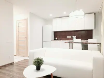 a white living room with a white couch and a table at M&M Apartment II SELF CHECK-IN in Panevėžys