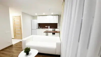 a white living room with a white couch and a table at M&M Apartment II SELF CHECK-IN in Panevėžys