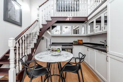 a kitchen with a table and chairs and a staircase at Luxury Gaono in Old Town in Vilnius