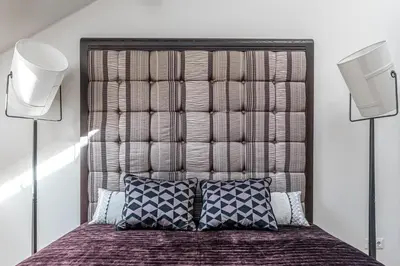 a bedroom with a large bed with two speakers at Luxury Gaono in Old Town in Vilnius