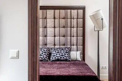 a bed with a wooden headboard in a bedroom at Luxury Gaono in Old Town in Vilnius