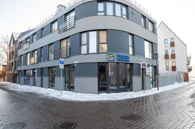 a large building on a street with snow on the ground at Luxurious Blue&Yellow Apartment in Kaunas Center in Kaunas