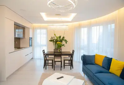 a living room with a blue couch and a table at Luxurious Blue&Yellow Apartment in Kaunas Center in Kaunas