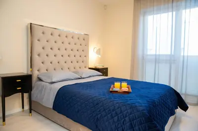 a bedroom with a blue bed with a tray of drinks on it at Luxurious Blue&Yellow Apartment in Kaunas Center in Kaunas