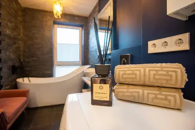 a bottle of perfume sitting on a table in a bathroom at Luxurious Blue&Yellow Apartment in Kaunas Center in Kaunas