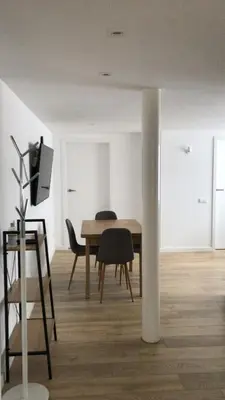 a dining room with a table and chairs and a tv at City center apartment in Alytus