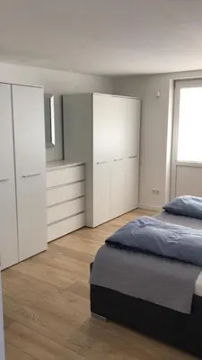 a bedroom with white cabinets and a bed at City center apartment in Alytus