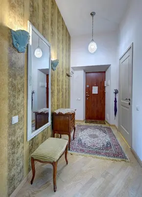 a hallway with a door and a mirror and a stool at Romantic City Center Apartment in Old Town in Vilnius