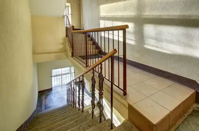 a staircase in a building with a wooden railing at Romantic City Center Apartment in Old Town in Vilnius