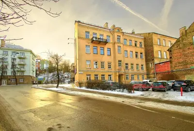 a large building with cars parked in a parking lot at Romantic City Center Apartment in Old Town in Vilnius