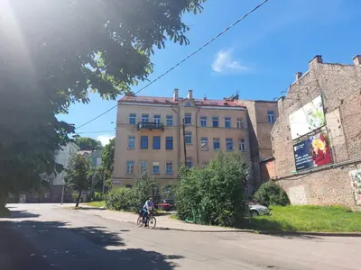 a person riding a bike in front of a building at Romantic City Center Apartment in Old Town in Vilnius