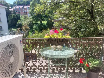 a table on a balcony with a fan and flowers at Romantic City Center Apartment in Old Town in Vilnius