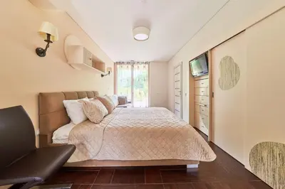 a bedroom with a bed and a chair in it at Luxury villas Kaunas in Šlienava