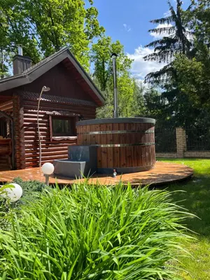 a wooden deck with a hot tub in front of a cabin at Luxury villas Kaunas in Šlienava
