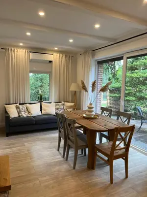 a living room with a wooden table and a couch at Luxury villas Kaunas in Šlienava