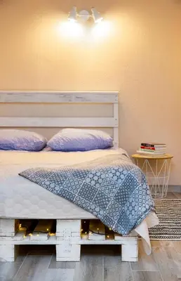 a bedroom with a white bed with purple pillows at Apartment in Garage with free parking in Kaunas
