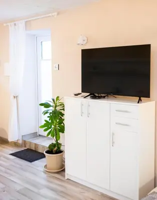 a living room with a flat screen tv on a white cabinet at Apartment in Garage with free parking in Kaunas