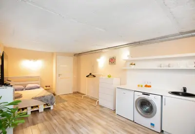 a bedroom with a bed and a washing machine at Apartment in Garage with free parking in Kaunas