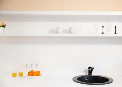 a kitchen counter with a sink and a plate of oranges at Apartment in Garage with free parking in Kaunas