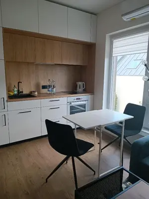 a kitchen with a table and chairs in a room at Žvėrynas Workation apartments in Vilnius