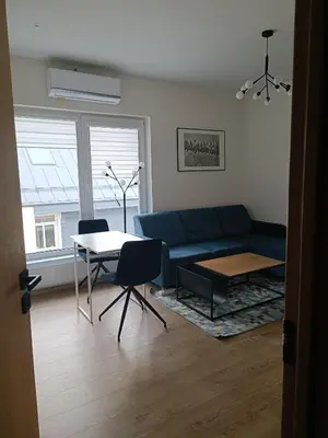 a living room with a blue couch and a table at Žvėrynas Workation apartments in Vilnius