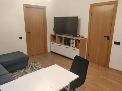 a living room with a tv and a table and a couch at Žvėrynas Workation apartments in Vilnius