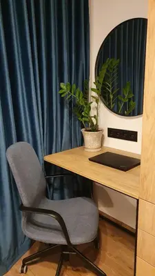 a desk with a chair next to a table with a laptop at Žvėrynas Workation apartments in Vilnius