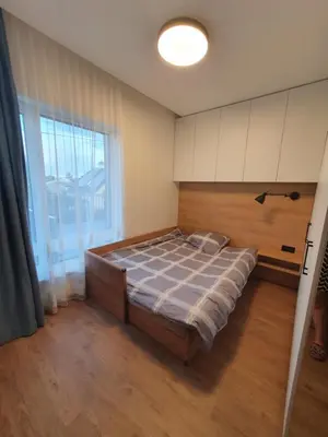 a bedroom with a bed and a large window at Žvėrynas Workation apartments in Vilnius