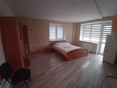 a bedroom with a bed and two windows at Butas miesto centre - bulvare in Šiauliai