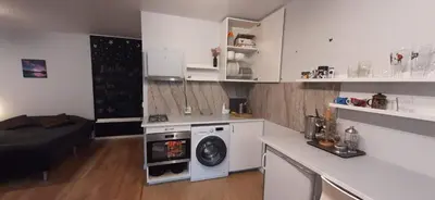 a kitchen with a washing machine in a white kitchen at Elite Flats Two bedroom in Utena
