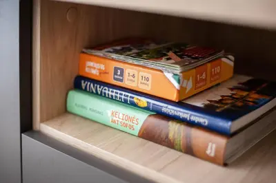 four books stacked on top of each other on a shelf at #stayhere Modern & Compact 1BDR Uptown Vilnius in Vilnius