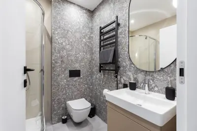 a bathroom with a toilet and a sink and a mirror at #stayhere Modern & Compact 1BDR Uptown Vilnius in Vilnius